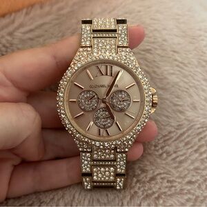 Woman’s Michael Kors rose gold watch.
